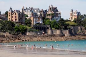 un groupe de personnes dans l'eau d'une plage dans l'établissement Studio centre Dinard, à Dinard