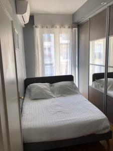 a bedroom with a bed and two windows at 29 Promenade des Anglais in Nice