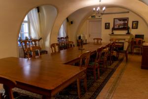 a dining room with tables and chairs and a piano at Hotel Wollner in Sopron