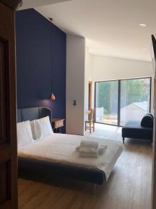 a bedroom with a large bed with a blue wall at Montesinho Eco-Resort in Bragança