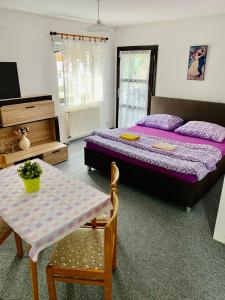 ハルラホフにあるPension Lenka 2のベッドルーム1室(ベッド2台、テーブル、テーブル・シドックスシドックス付)