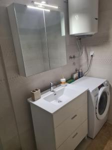 a bathroom with a sink and a washing machine at Budva Centar in Budva +2 photos