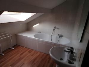 uma casa de banho com uma banheira e um lavatório em Bienvenue en Gaume ! em Izel