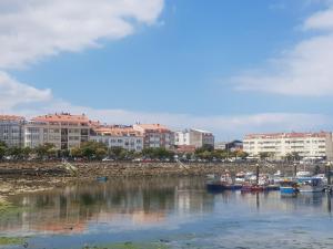 una ciudad con edificios y barcos en un cuerpo de agua en Portosin puerto, en Portosín