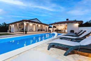 een zwembad met ligstoelen naast een huis bij Villa Miracolo in Rovinj