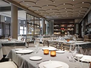 a restaurant with tables and chairs with white table linens at Grand Hotel De La Ville in Parma