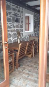 a dining room with a table and chairs and a stone wall at Apartman Hana in Tivat +14 photos
