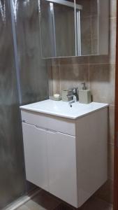 a bathroom with a white sink and a shower at Apartman Hana in Tivat