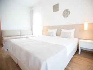 a large white bed in a room with a window at Tavira Monte in Tavira