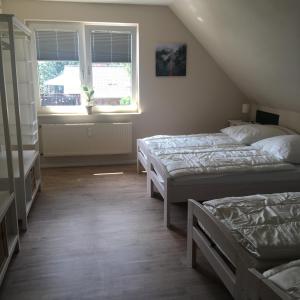 a bedroom with two beds and a window at Landhaus von Frieling - Neuenkirchen in Neuenkirchen