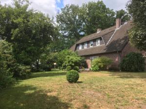 a brick house with a bush in the yard at Landhaus von Frieling - Neuenkirchen in Neuenkirchen