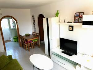 un soggiorno con televisione e tavolo di Portobello Verena a Port de Pollença