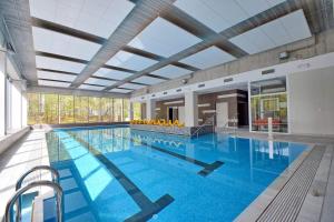 a large swimming pool in a large building at Aquamarina Onyx 18 in Międzyzdroje
