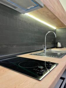 a kitchen counter with a sink and a stove at Agora LX Studios & Suites in Thessaloniki