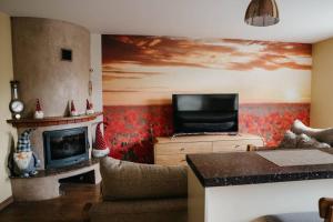 ein Wohnzimmer mit einem TV und einem Kamin in der Unterkunft Lovely apartment for families and couples in Liepāja