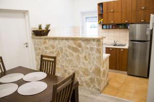 a kitchen with a table and a stainless steel refrigerator at White Orchid Pula in Pula