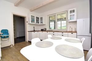 a kitchen with white cabinets and a table and chairs at Siedlisko Podjaworzem in Grybów