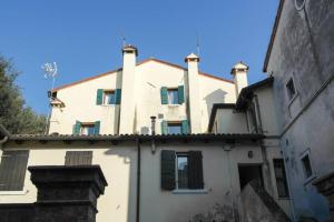 Una casa blanca con persianas verdes encima. en Ca' Pescheria, en Treviso