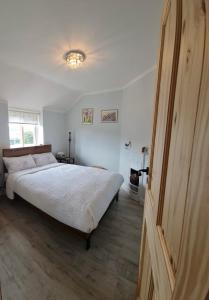 a bedroom with a large bed and a window at Cosy double room in a seaside cottage in Crafthole