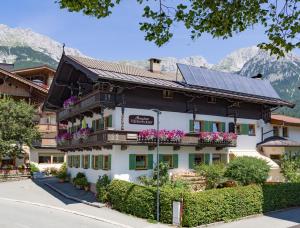 a building with solar panels on the roof at Pension Hinterholzer in Scheffau am Wilden Kaiser