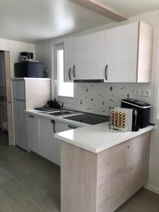 a kitchen with white cabinets and a white counter top at Nalu Seahouse in Portorož