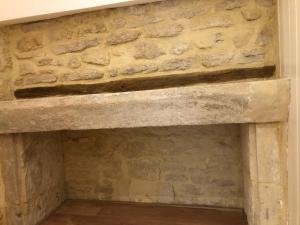 a stone fireplace in a room with a stone wall at Maison de pêcheur de 1820 au cœur du bourg - 3 étoiles in Ouistreham