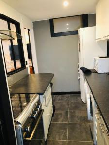 uma cozinha com geladeira e bancada em Maison de pêcheur de 1820 au cœur du bourg - 3 étoiles em Ouistreham mais 11 fotografias