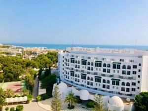 ein weißes Gebäude mit dem Ozean im Hintergrund in der Unterkunft Byblos Sousse in Sousse