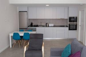- une cuisine avec une table et des chaises bleues dans l'établissement Apartment Rosa - Brand new 2 bedroom apartment in Cantal Homes, Ventanicas, Mojacar, à Mojácar