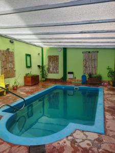 una grande piscina in una stanza con pareti verdi di Hotel Brisas Marinas a San Clemente del Tuyú