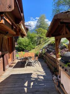 una terraza de madera con mesa y sillas. en Chalet massif du Mont Blanc St Gervais Megeve en Saint-Gervais-les-Bains