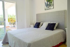 sypialnia z dużym białym łóżkiem i niebieskimi poduszkami w obiekcie Villa Bendex Estepona Costa Del Sol w mieście Estepona +37 zdjęć