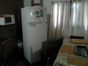 um frigorífico branco num quarto com uma mesa em La Mima em Capilla del Monte