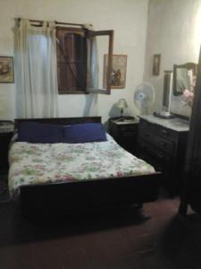 a bedroom with a bed and a dresser at La Mima in Capilla del Monte