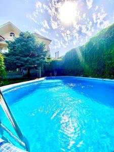 a pool of blue water in front of a house at Ridon Lux Hotel in Tashkent