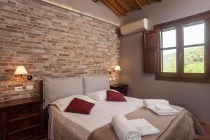um quarto com uma cama grande e uma parede de tijolos em Casa vacanza Asfodeli em Teulada