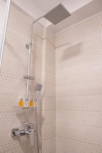 La salle de bains est pourvue d'une douche avec une porte en verre. dans l'établissement City Rooms, à Sighetu Marmaţiei