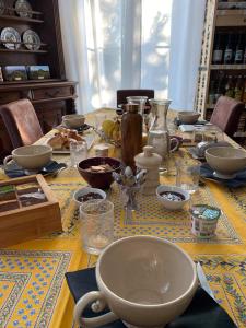 einen Tisch mit Schalen und Geschirr darüber in der Unterkunft La maison de Maria in Saint-Beauzire