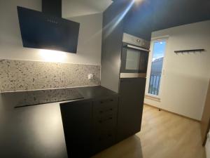 a kitchen with a black counter top and a window at Apartament 87 in Szczecin +4 photos