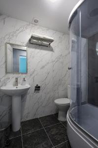 La salle de bains est pourvue d'un lavabo, de toilettes et d'un miroir. dans l'établissement PANORAMA BRIZ, à Zatoka