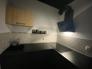 une cuisine avec un évier et une lumière sur le mur. dans l'établissement Apartament 87, à Szczecin