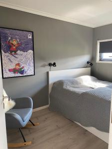 1 dormitorio con 1 cama, 1 silla y 1 pintura en Lys og moderne leilighet rett ved skiløypa på Nordseter - Kort vei til Sjusjøen, Lillehammer og Hafjell - Dyr ikke tillatt en Nordseter