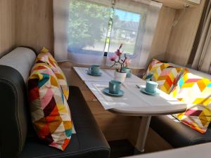a table with two chairs and a table with cups on it at Caravane tractable in Paliseul