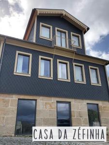 a black house with a sign in front of it at Casa da Zéfinha, em Cinfães, no Douro in Cinfães