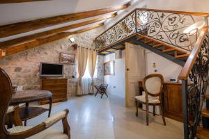 a living room with a staircase and a tv at Hotel Villa Duomo in Kotor