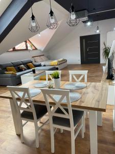 a dining room and living room with a table and chairs at Apartament Rynek 13 z parkingiem - Centrum Bochni in Bochnia