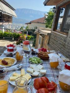 a table with cheese and other foods on it at Ahmetaj Guest House in Gjirokastër