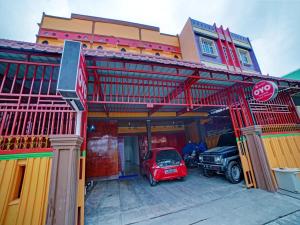 a red car parked in front of a building at OYO 90387 Sepakat Guest House in Medan