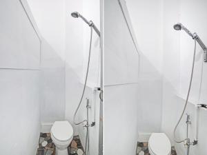 a bathroom with two toilets and a shower stall at OYO 90387 Sepakat Guest House in Medan