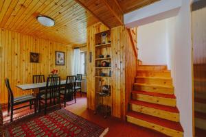 uma sala de jantar e cozinha com uma mesa e escadas em Highlander's House em Žabljak